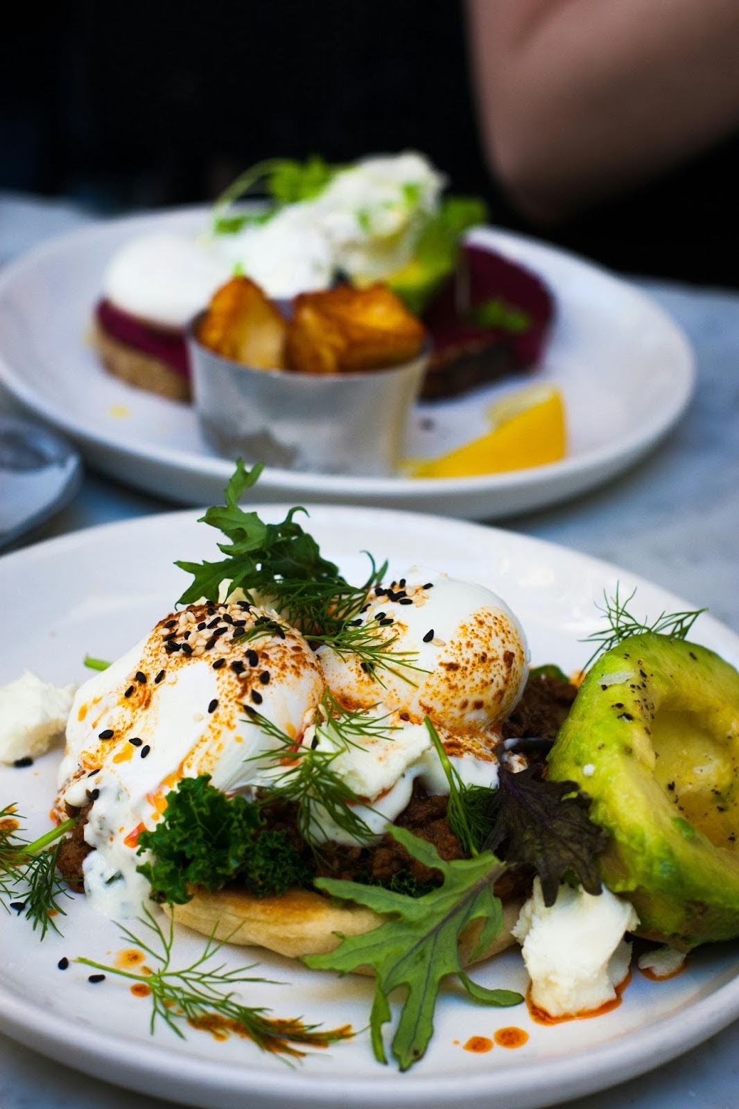 Poached eggs, avocado and herbs served on toast