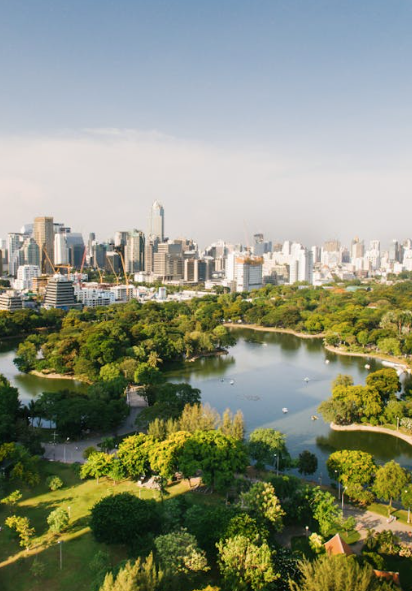 Leafy Bangkok park and lake with the city skyline beyond