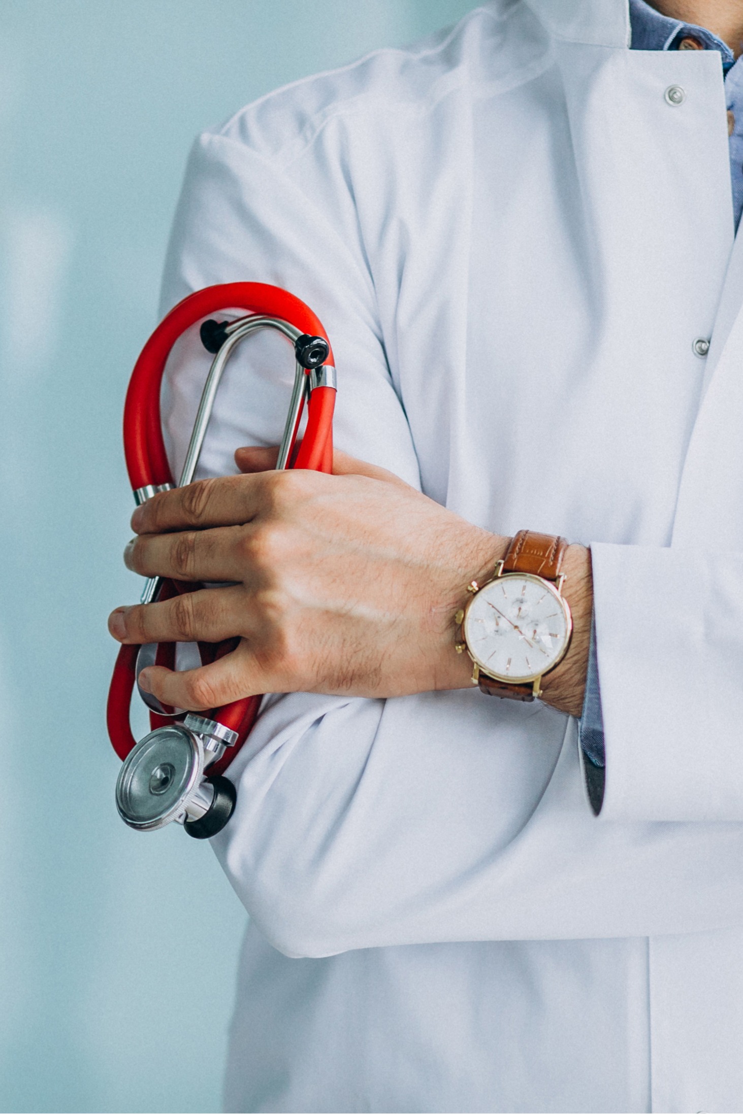 Medical professional holding a red stethoscope