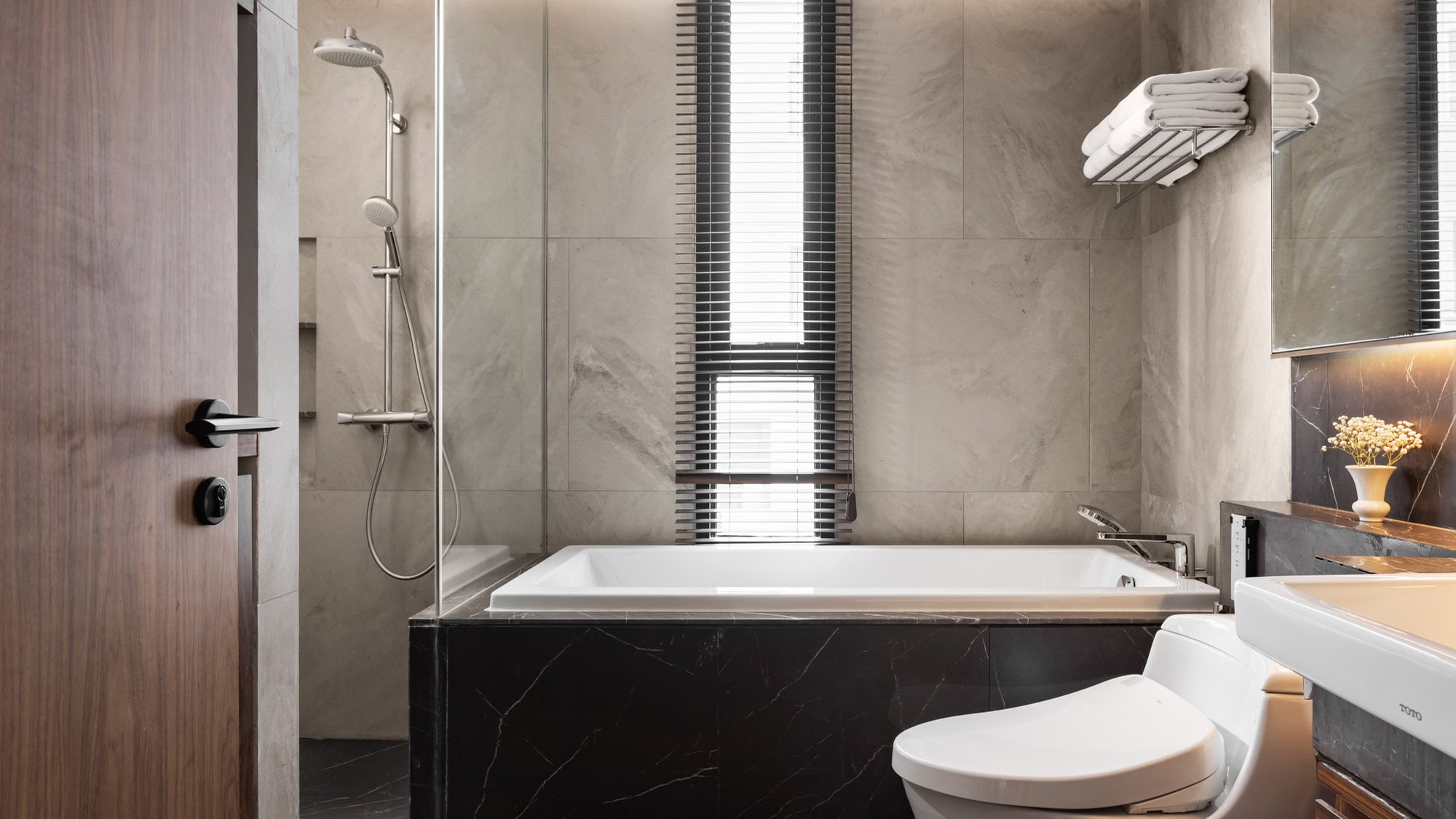 Walton Suites bathroom with a bathtub, glass shower and vanity
