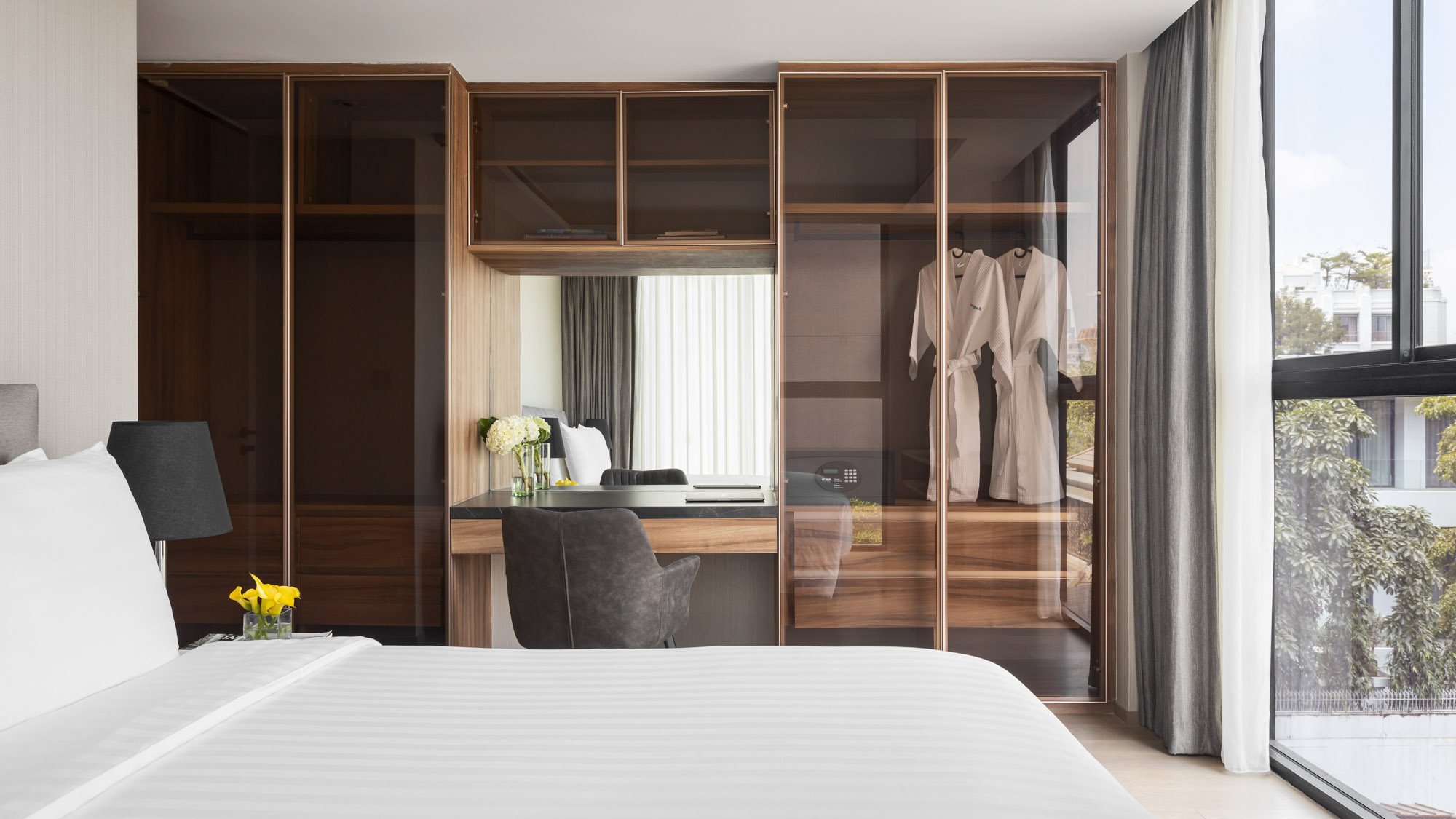 Walton Suites bedroom with a bed, dressing area and floor-to-ceiling windows